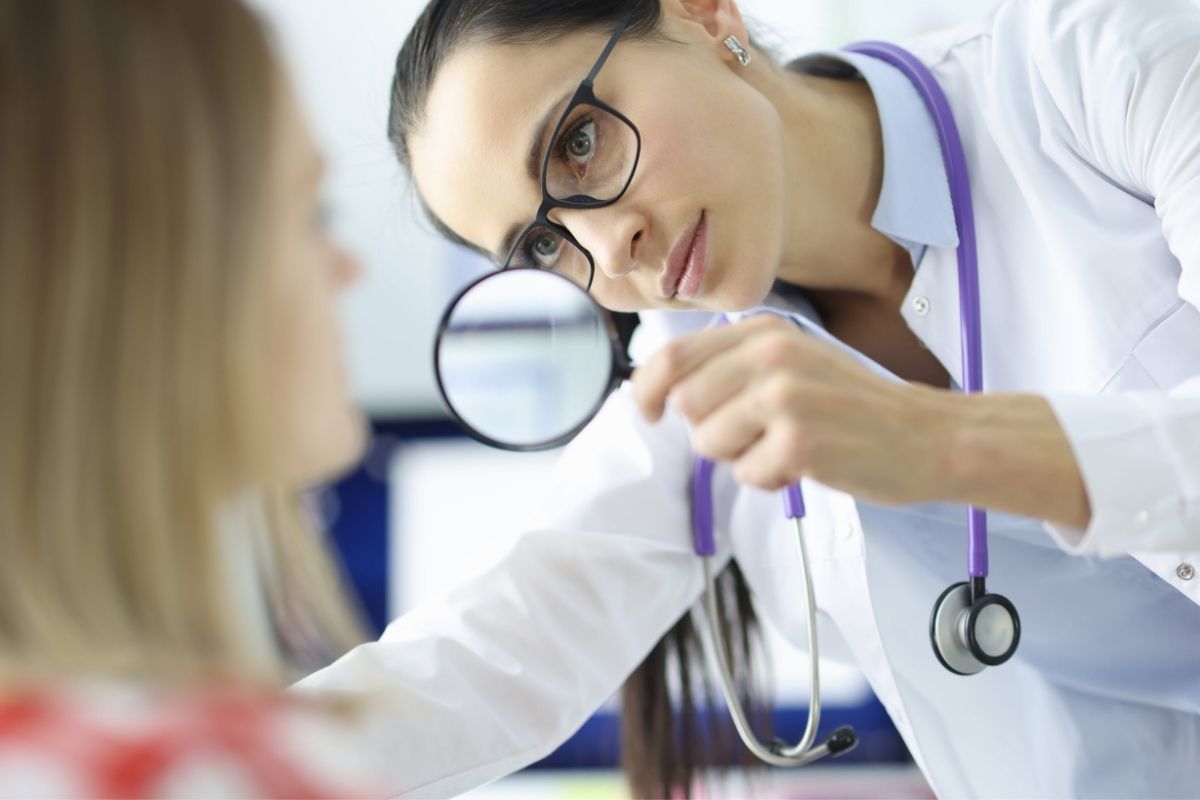 Dermatolog pregleda pigmentne promene na licu žene kako bi utvrdio vrstu hiperpigmentacije.